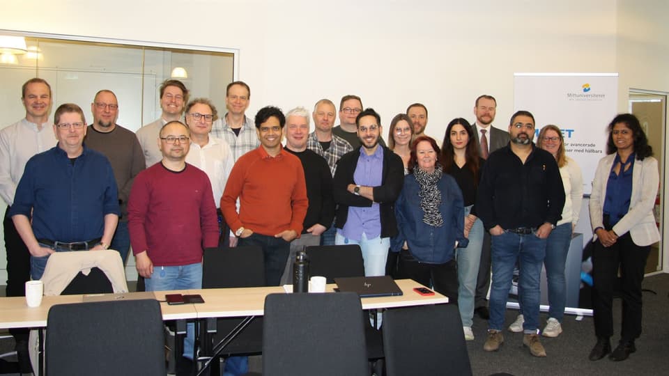  A group of people stand together in a conference room.