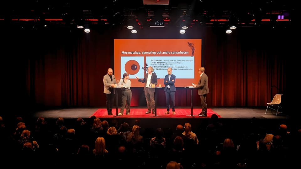 Fem talare står på en scen under evenemanget
