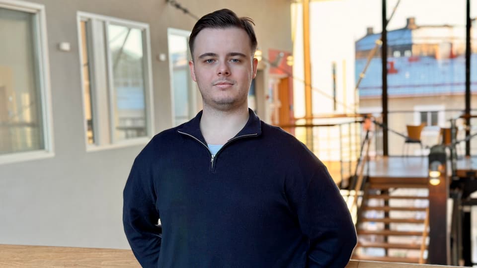 Man med mörkblå tröja och brunt hår.