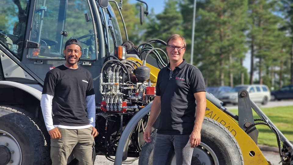 Två män framför en traktor