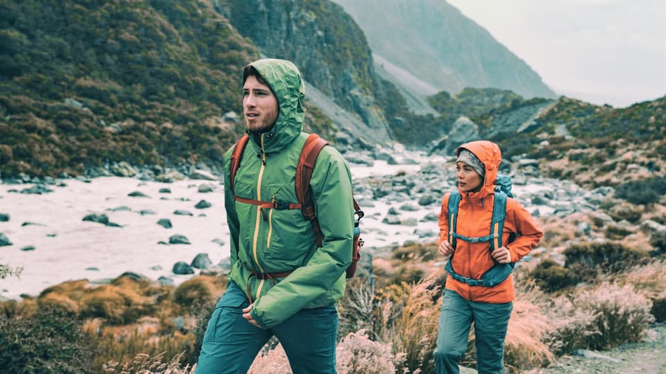 Hikers on trek with backpacks living healthy active lifestyle. Hiker girl walking on hike in mountain nature landscape.