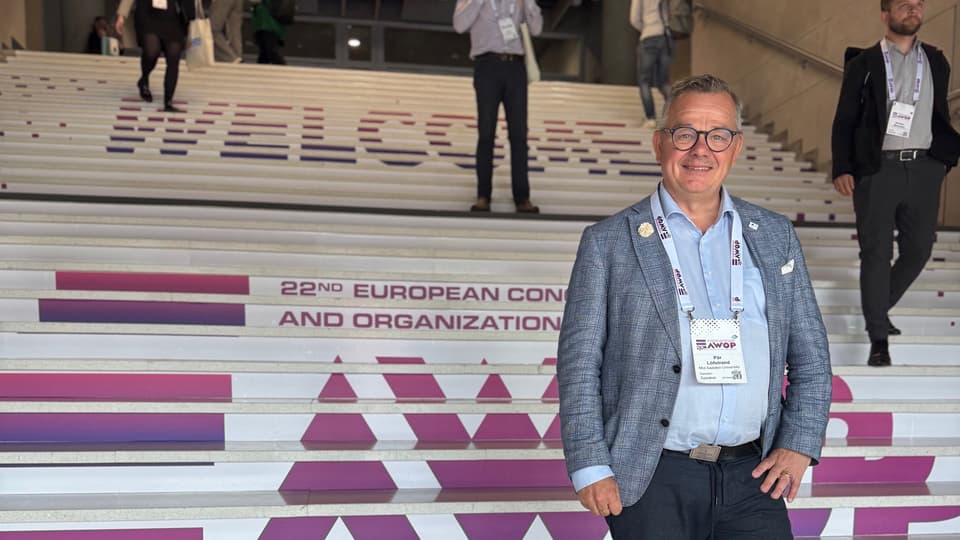 Man in a jacket standing on stairs.