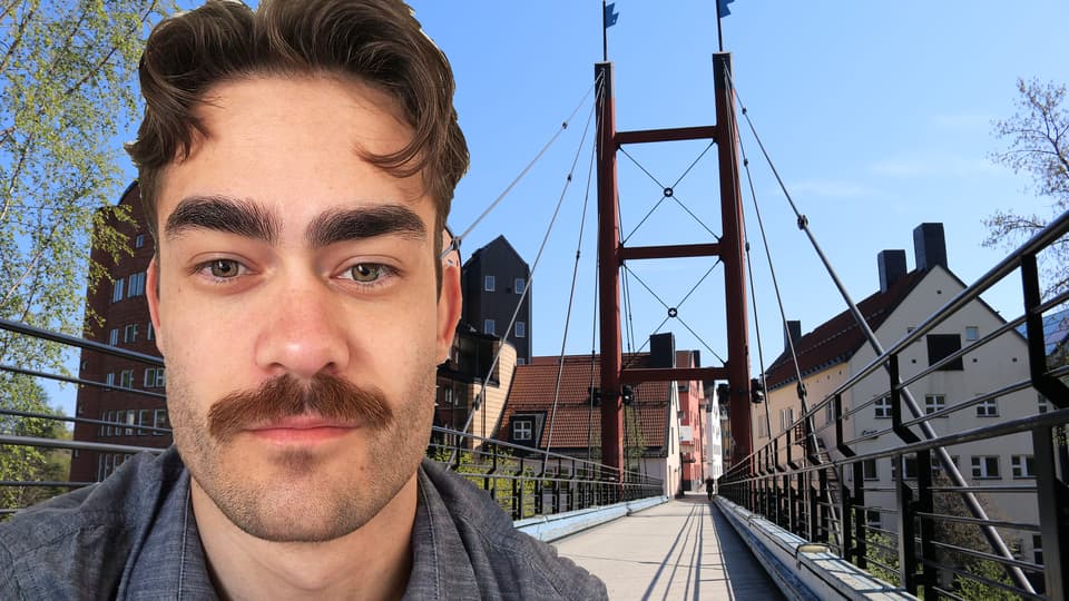 portrait of a man with a moustasch, in the background a bridge and buildings