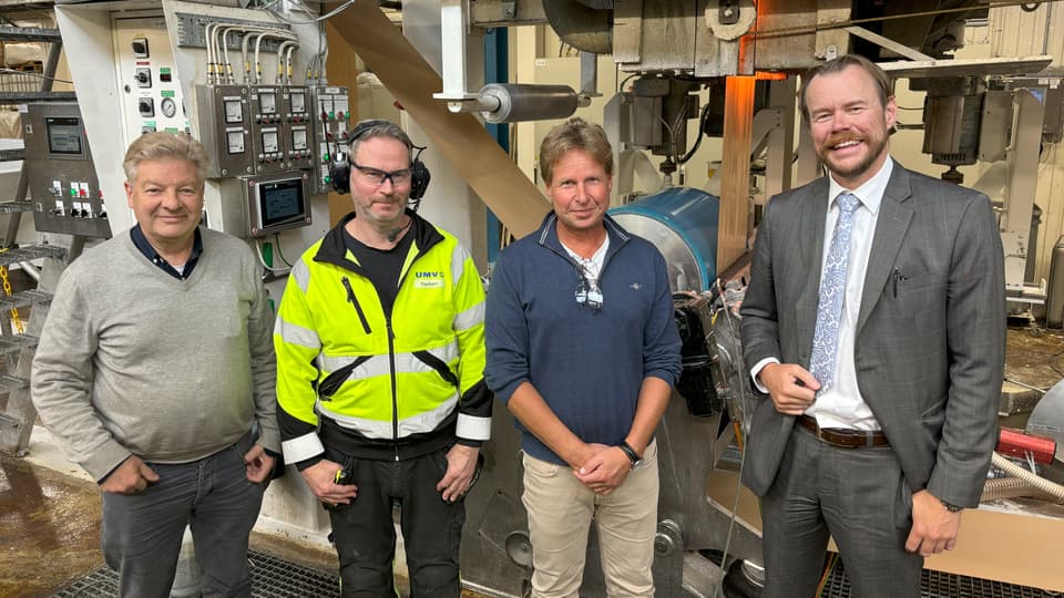  Four men standing together in an industrial building