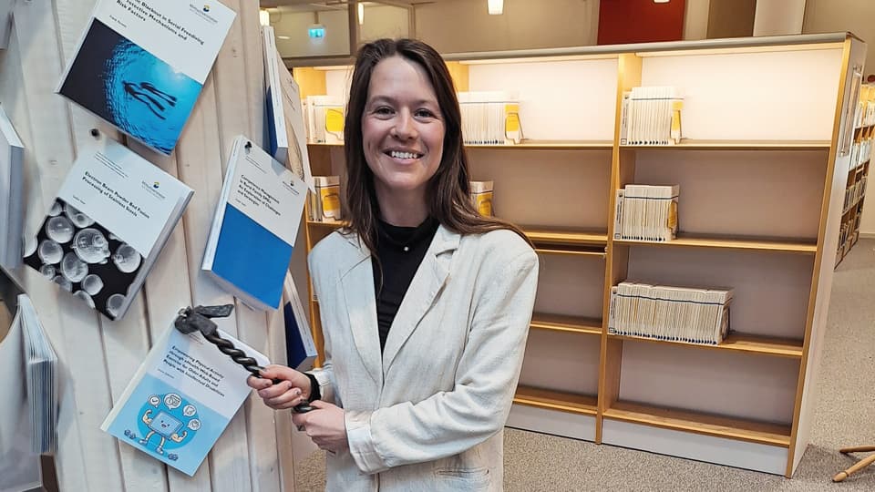 Kvinna spikar fast bok på en stolpe