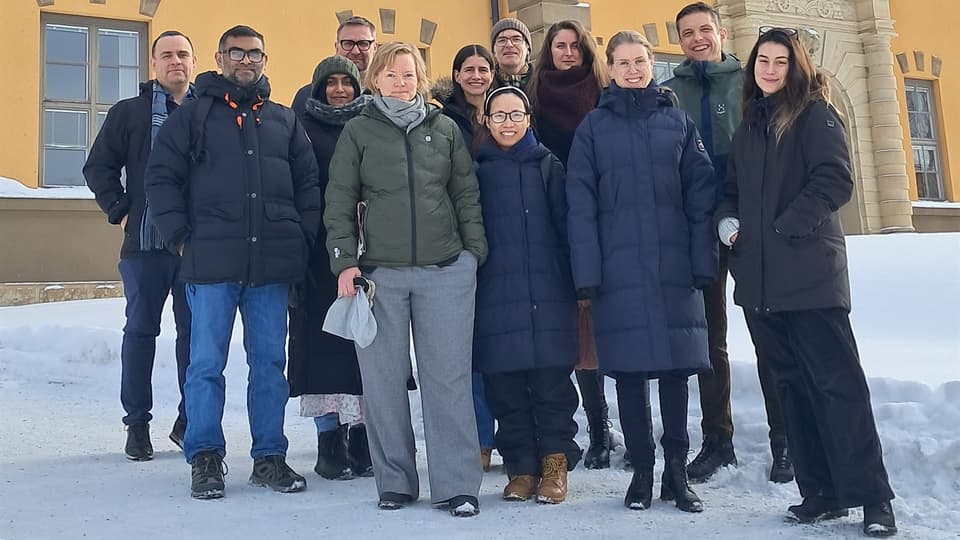 Grupp människor framför gul stenfasad