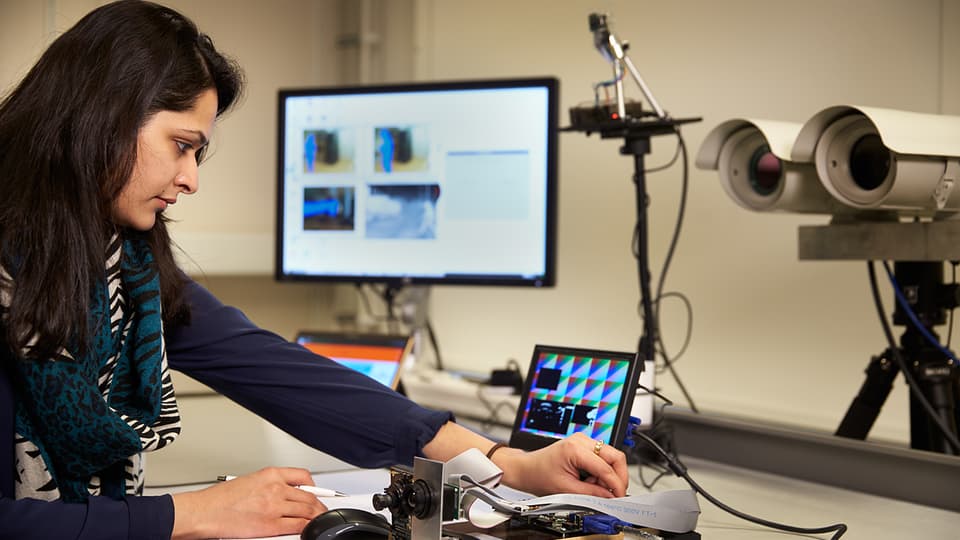 Woman using camera equipment in a lab.