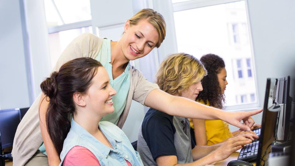  Datorlärare hjälper kvinnliga studenter i sin klass