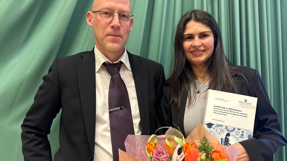 En man utan hår och med glasögon står bredvid en kvinna med långt svart hår