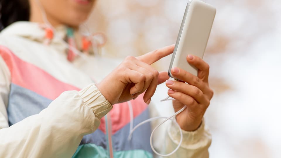 32199938-woman-listening-to-music-on-smartphone-outdoors.jpg