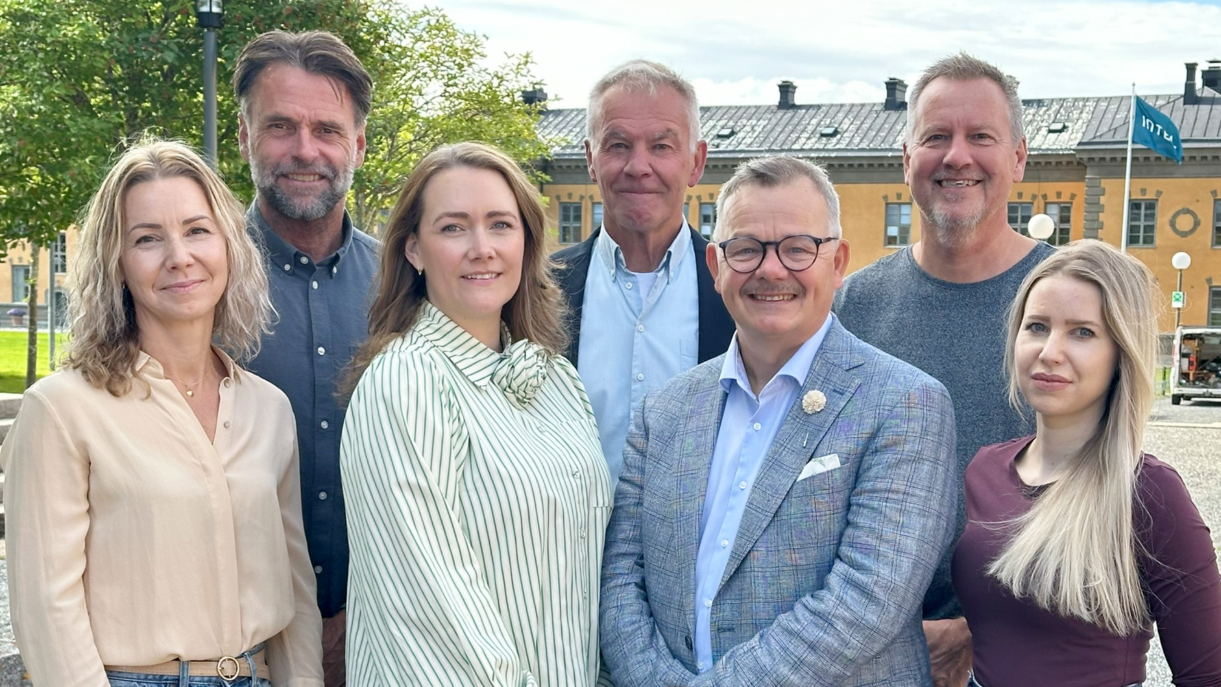 A group photo of seven people outdoors.