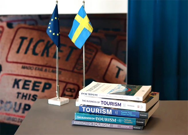 Turismböcker, en svensk flagga och en EU-flagga på ett bord