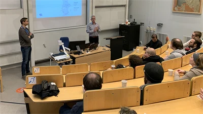 Studenter sitter i en föreläsningssal och lyssnar på en gästföreläsning.