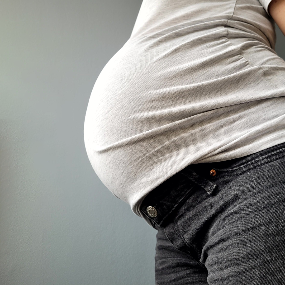 Gravid kvinna visar magen.