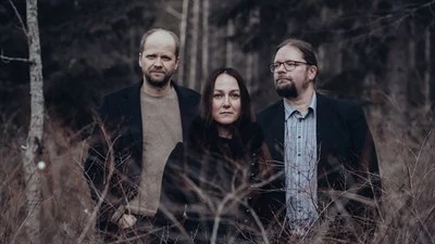 The music group Triakel standing in a forest