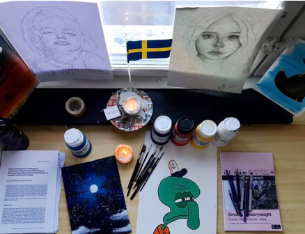 Skrivbord med teckningar och penslar