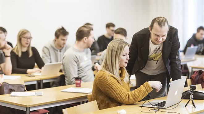 Klassrum – lärare hjälper student